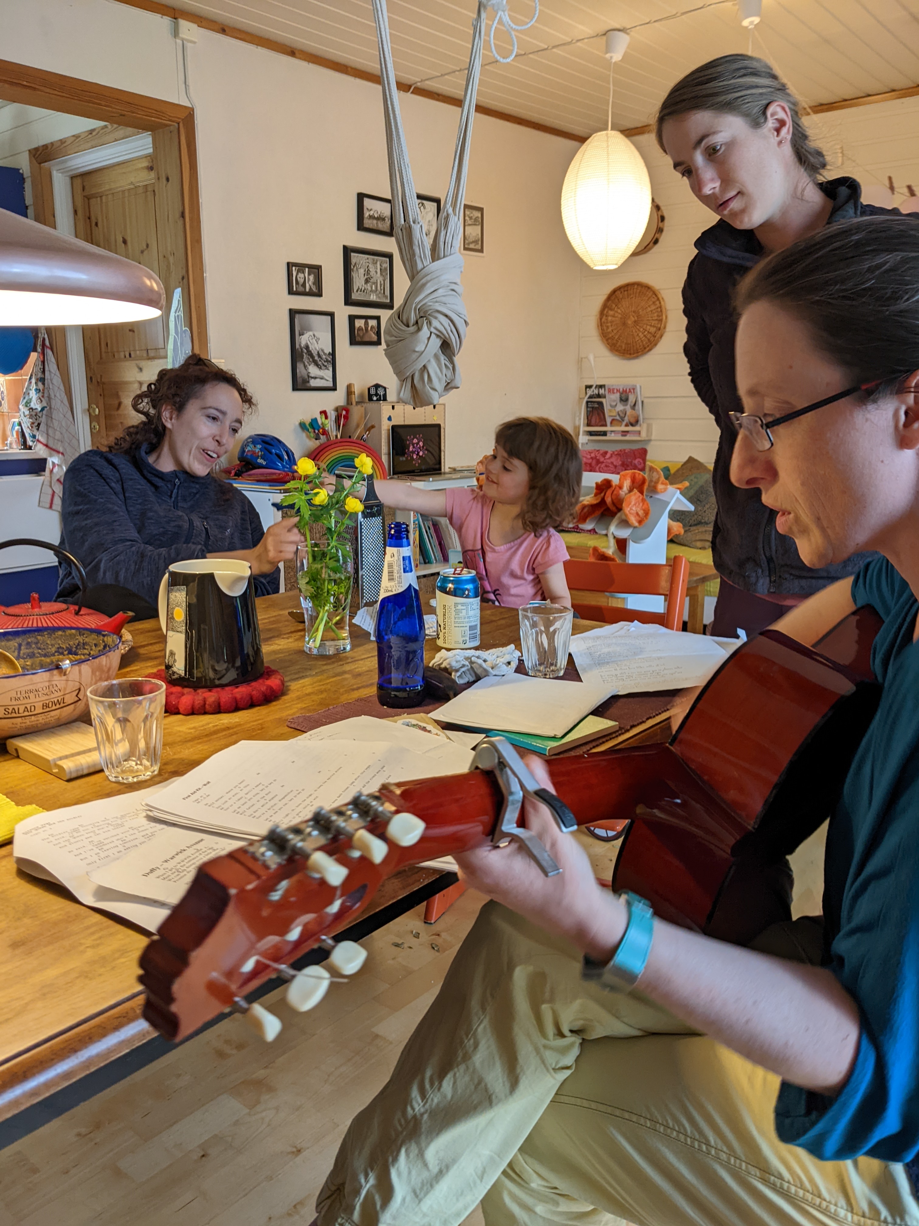 Jean playing guitar and singing, H reading music, Ira and Anouk playing in background