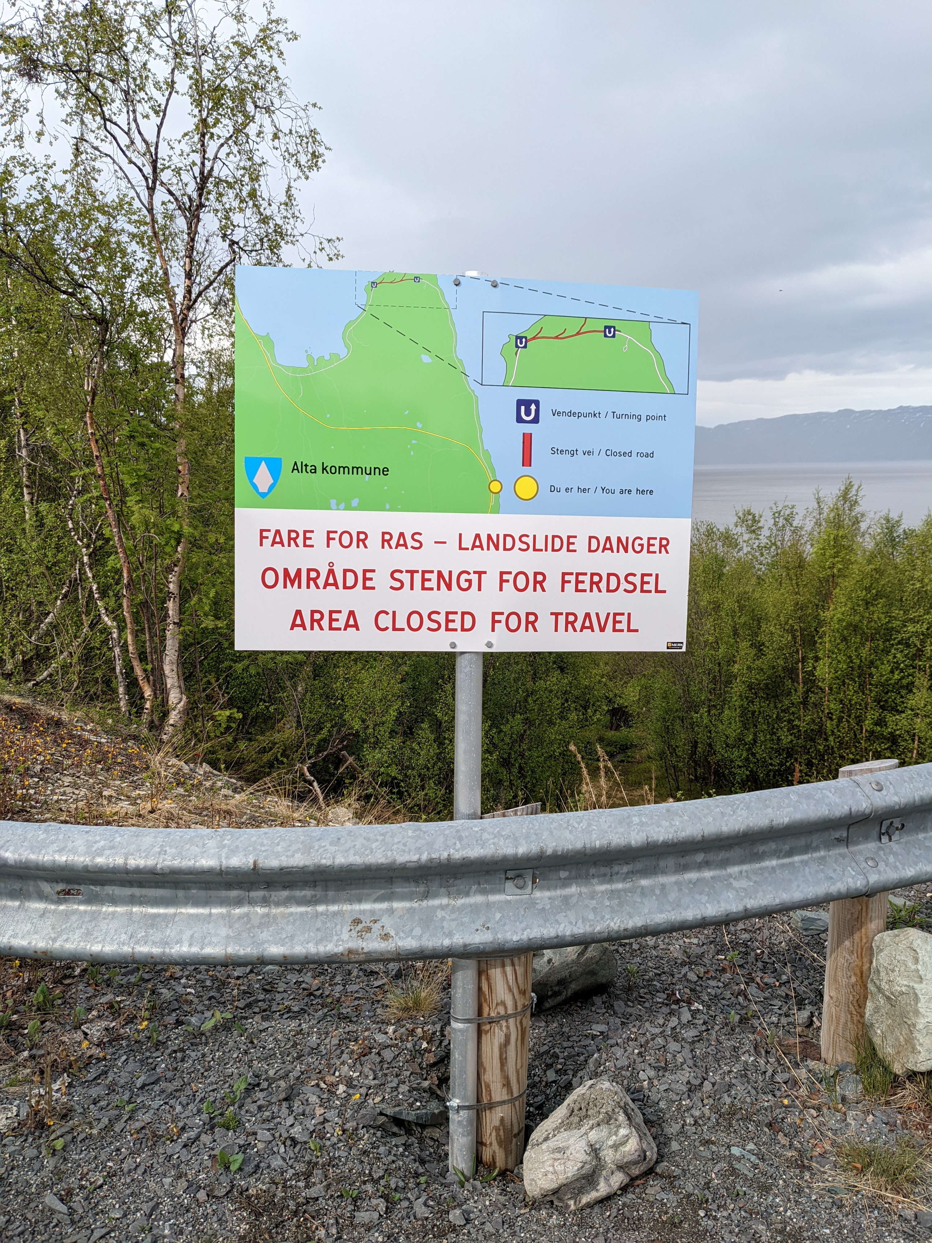 sign with map showing road closure and landslide risk area