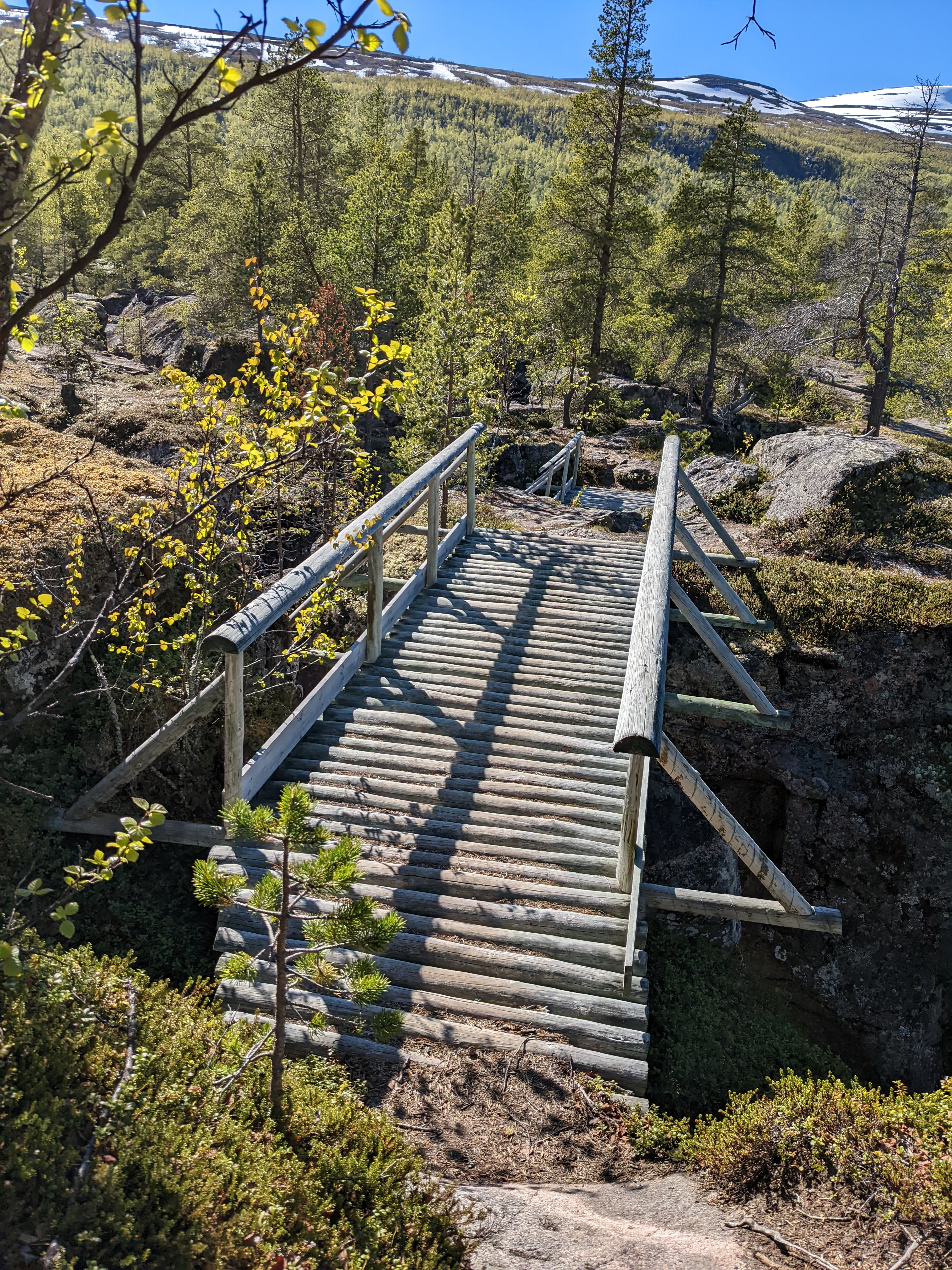 a well-built wooden bridge over a narrow chasm