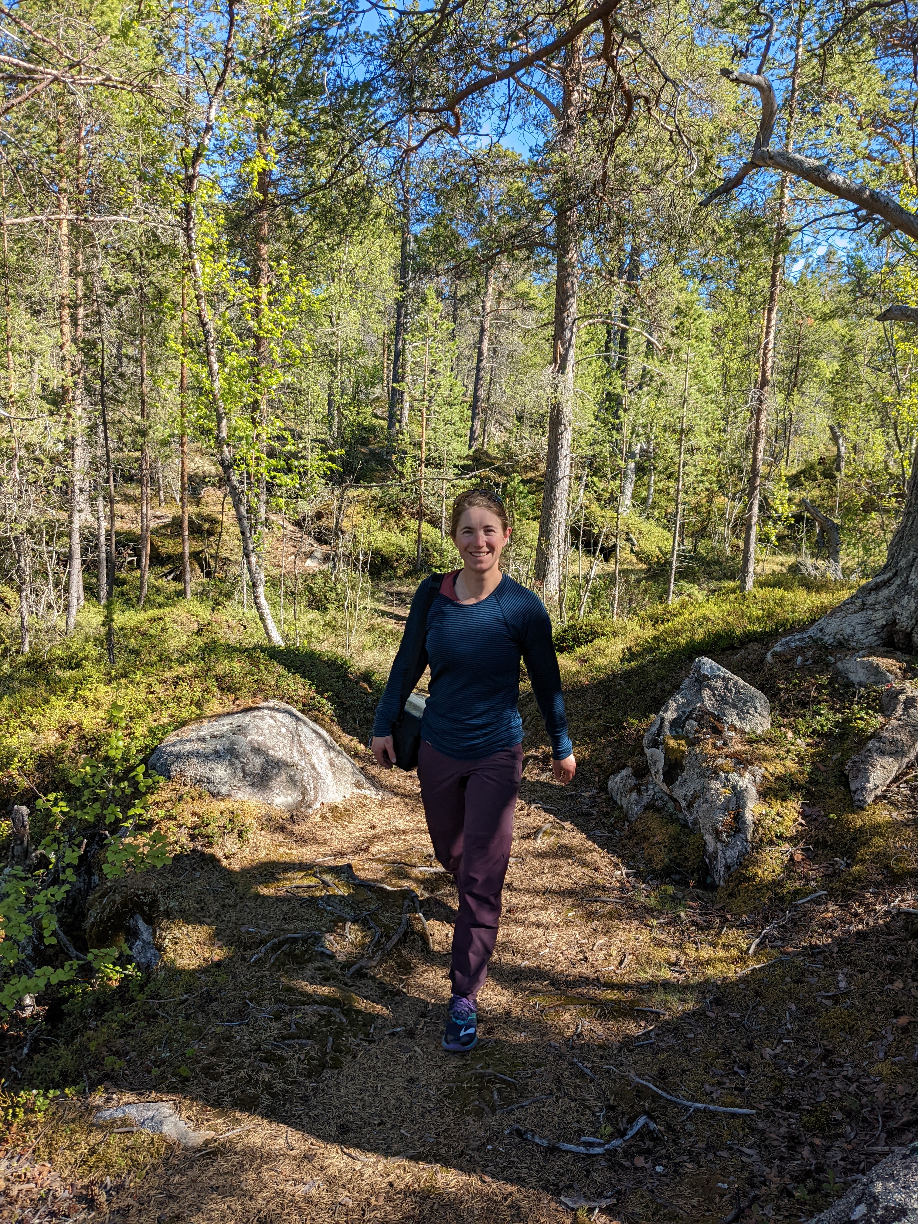 H walking up a path in a pine forest