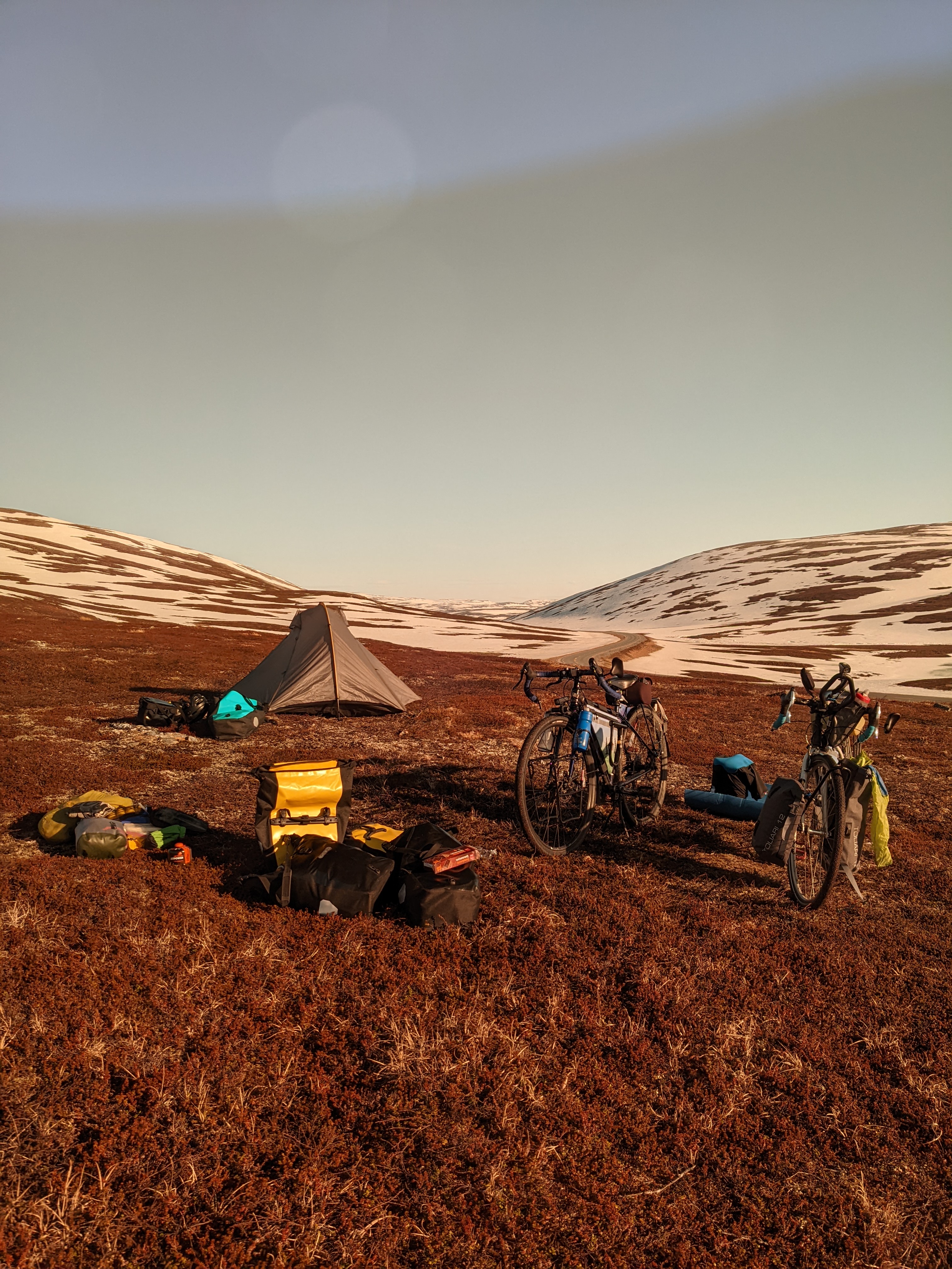 our high camp on an open slope above the road, snow in the backdrop