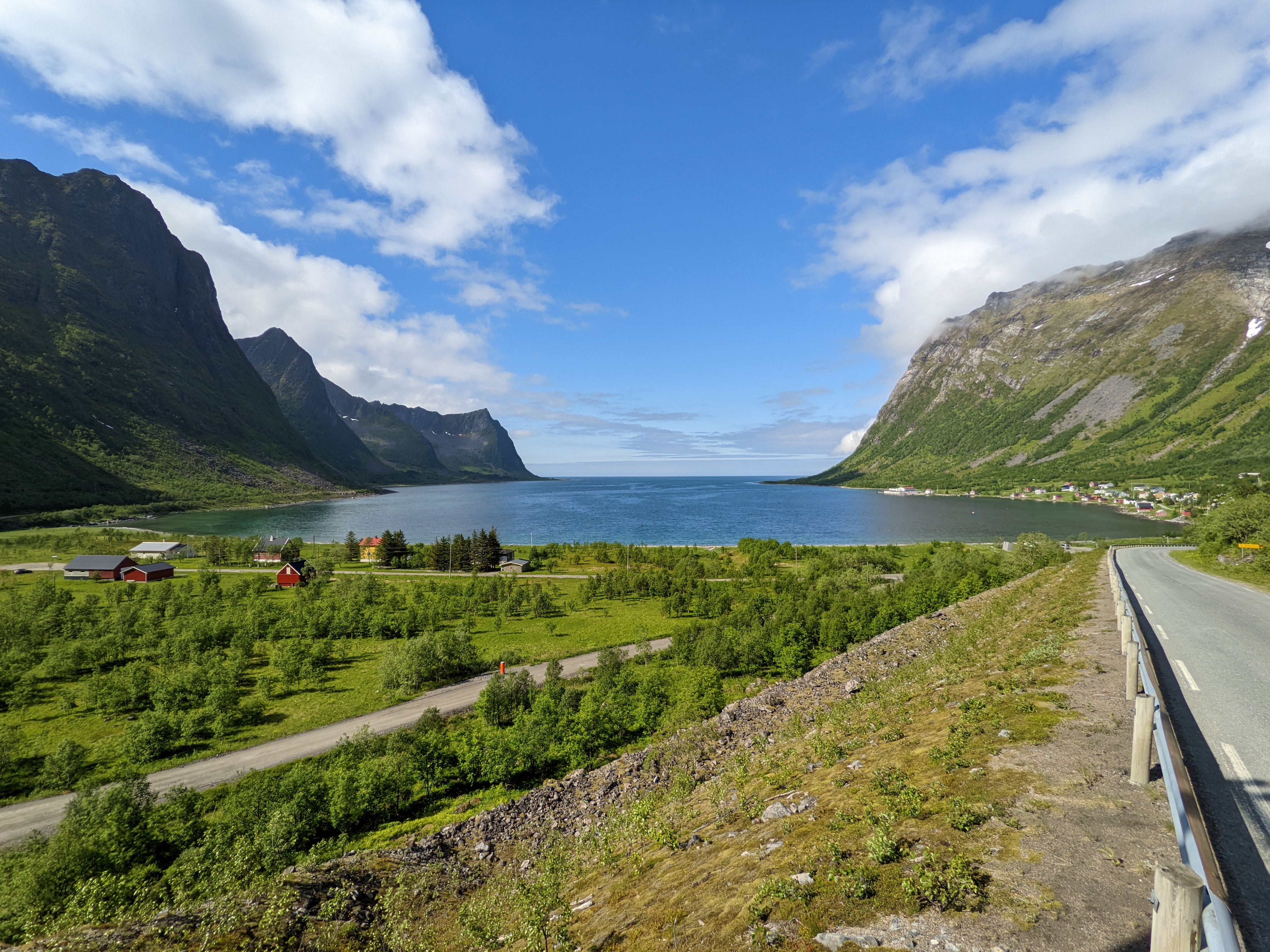 view down over another fjord end, with more houses, and u-shaped green walls on both sides