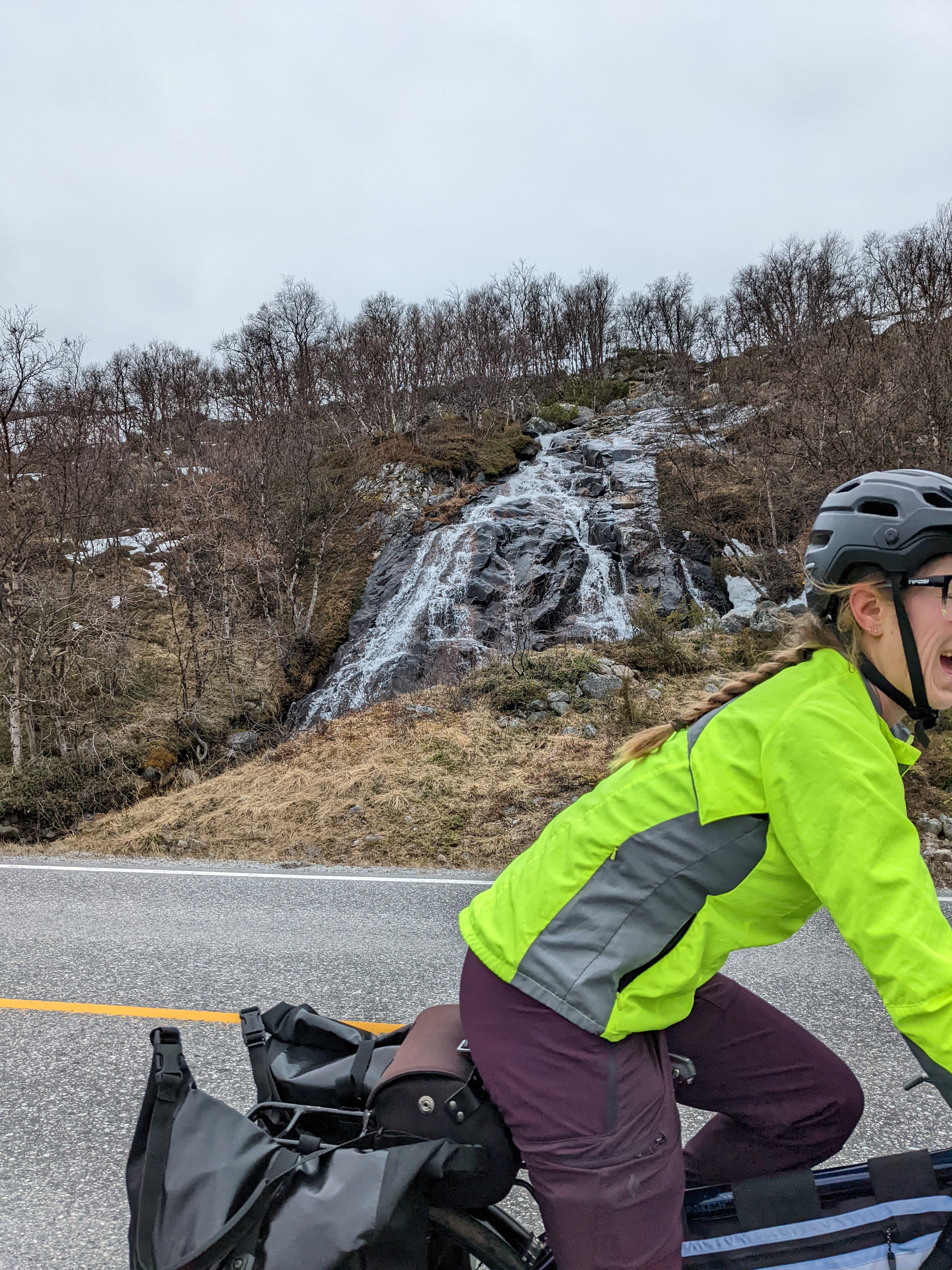 H riding out of the frame in front of a waterfall