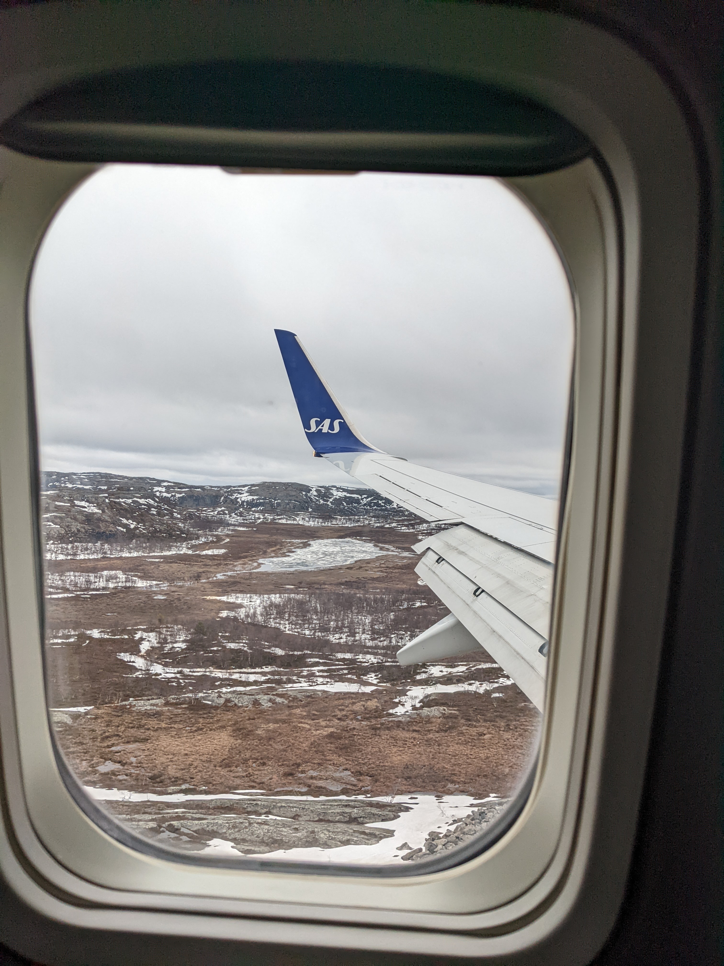 snow and rocky ground out airplane window