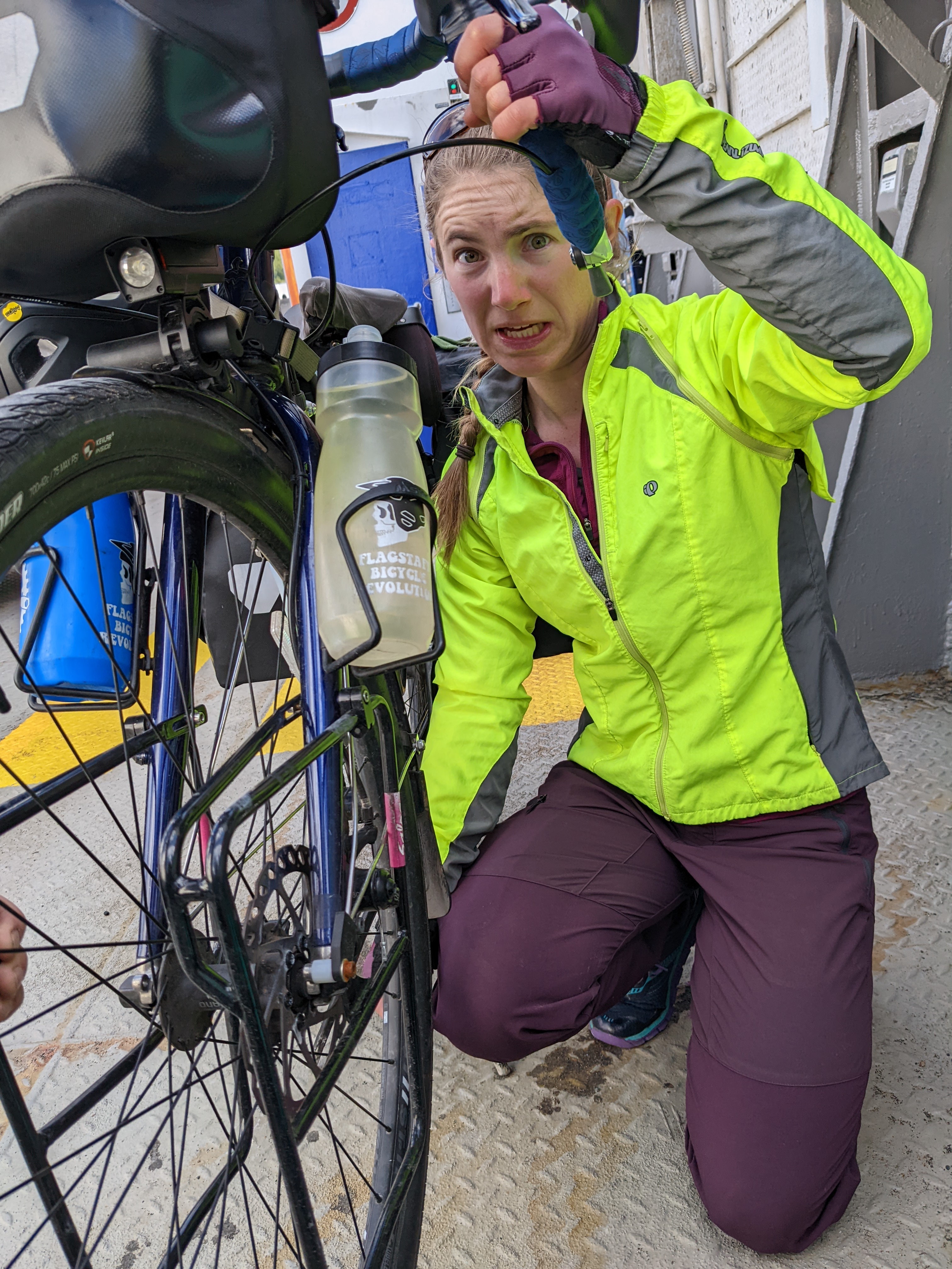 H making a terrible face while working on her brakes