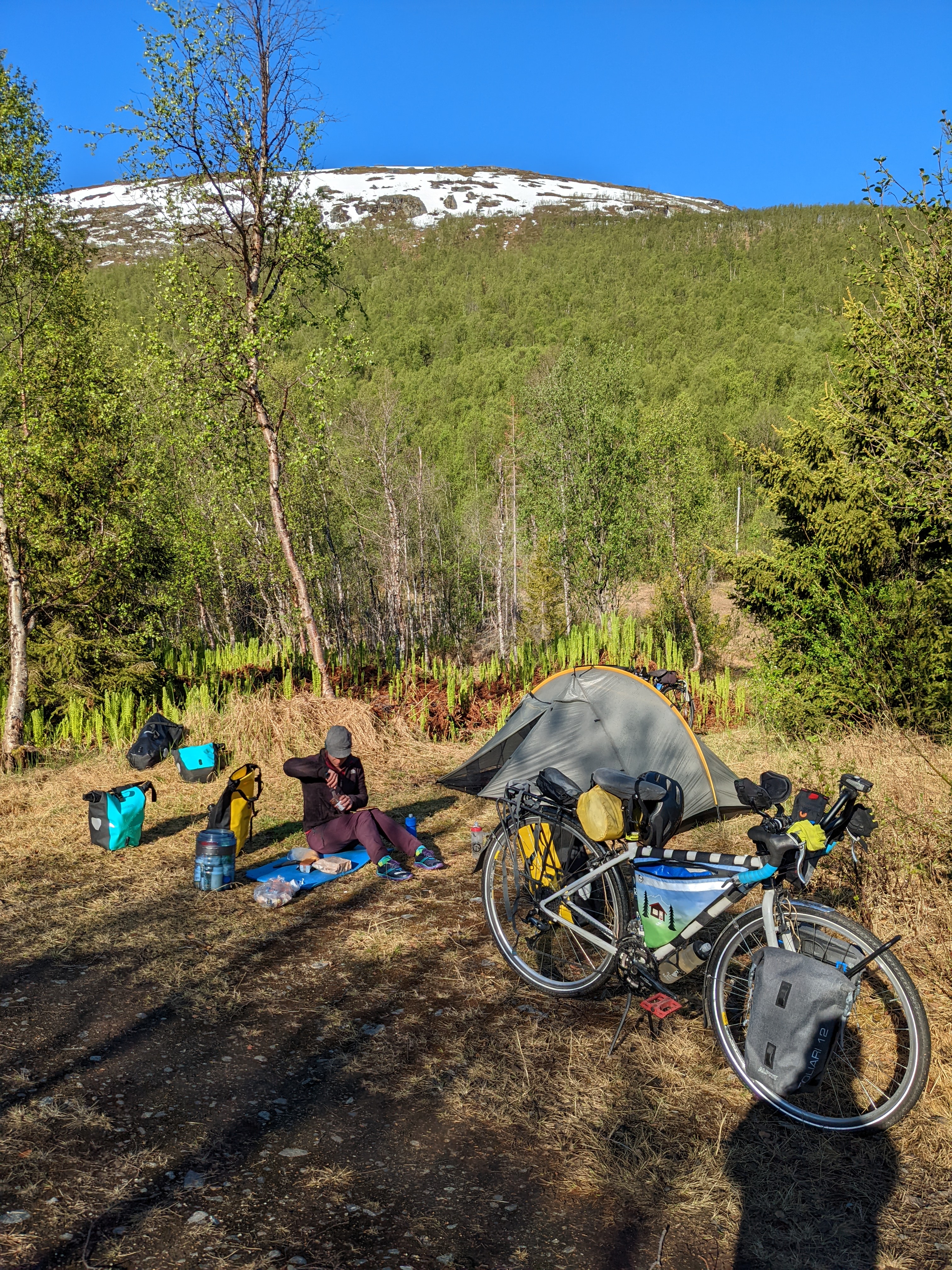 H preparing food by the tent in our little dry patch in the marsh