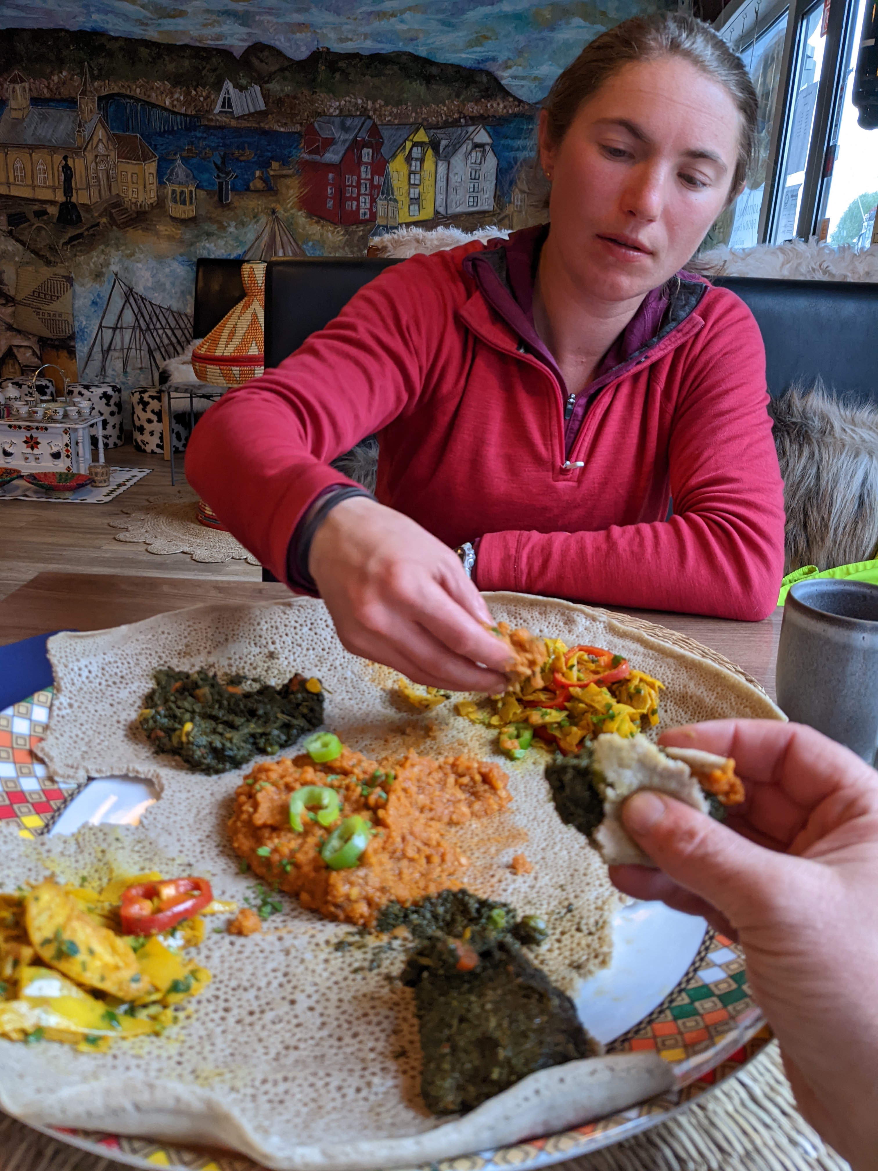 a plate of delicious Eritrean food and a tired H eating with her hands